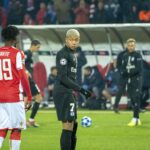 Kylian Mbappé standing on a football pitch