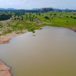 A lake on a farm in Bauchi State, Nigeria with trees and grassy shoreline