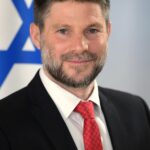 Portrait of Bezalel Smotrich wearing a dark suit and tie, facing forward