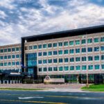 Exterior of an FBI field office building with the agency seal and flagpoles in front