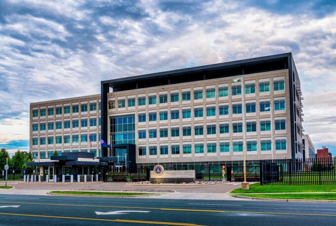 Exterior of an FBI field office building with the agency seal and flagpoles in front
