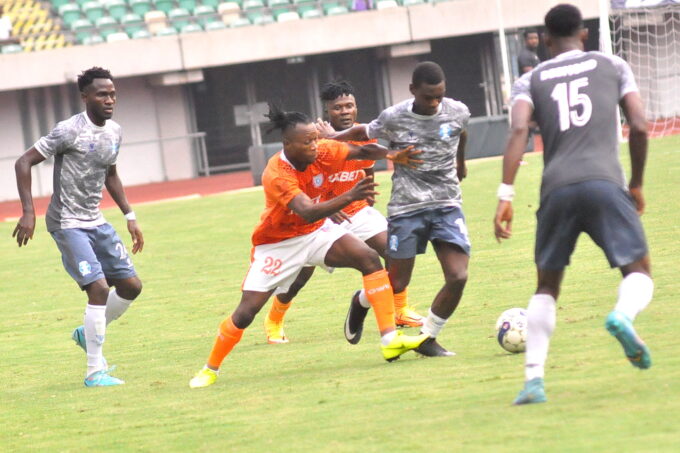 Shooting Stars players contest the ball with Akwa United during a NPFL match at Goodwill Akpabio Stadium