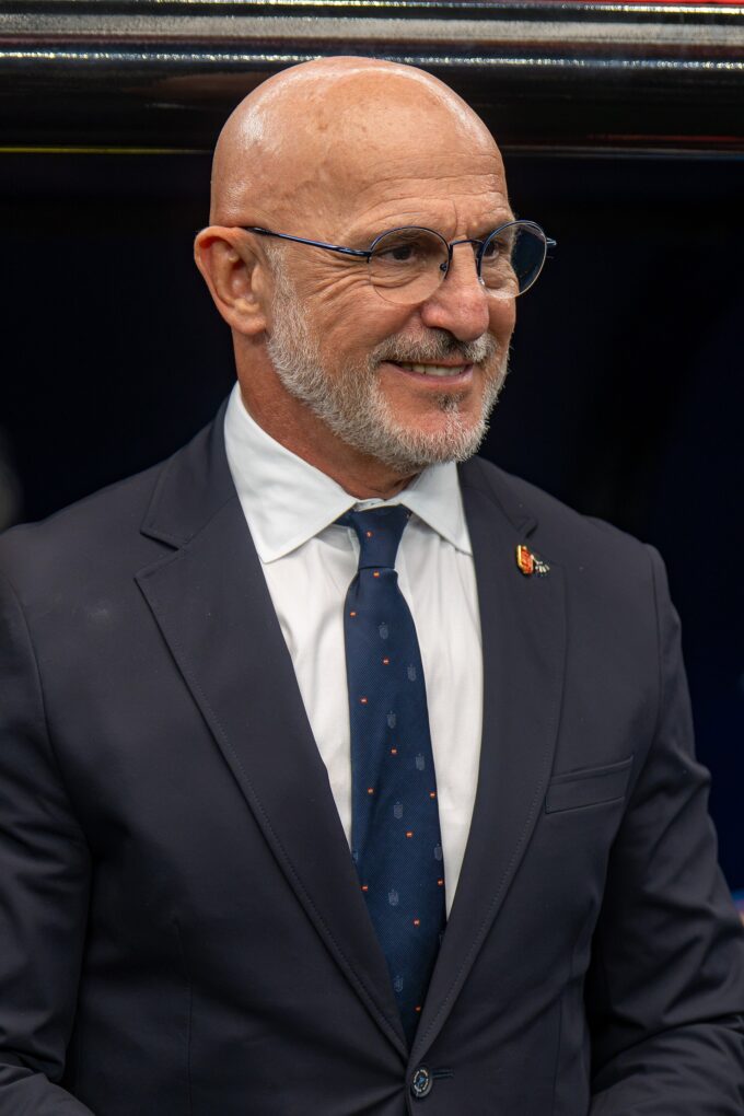 Luis de la Fuente on the touchline during an international match, gesturing while wearing Spain coaching attire