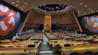 Interior view of the United Nations General Assembly hall with rows of seats and delegate desks