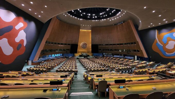 Interior view of the United Nations General Assembly hall with rows of seats and delegate desks