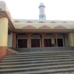Exterior view of Sultan Bello central mosque in Kaduna showing domes, minarets and entrance courtyard.