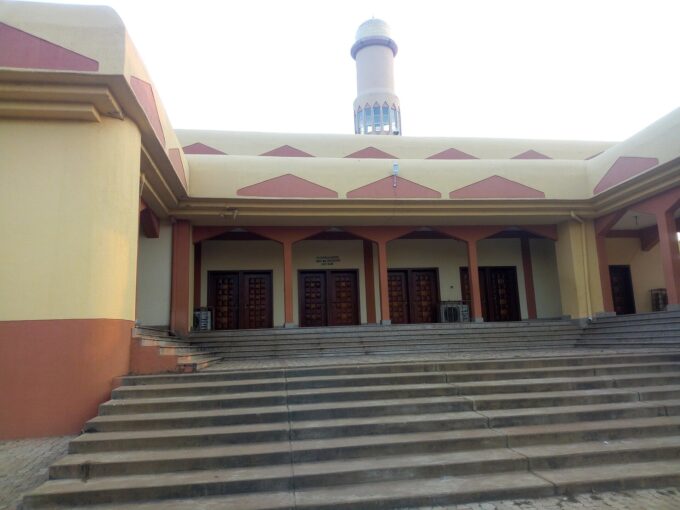 Exterior view of Sultan Bello central mosque in Kaduna showing domes, minarets and entrance courtyard.
