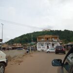 Front view of Ekiti State Government House building in Ado-Ekiti with palm trees and sky