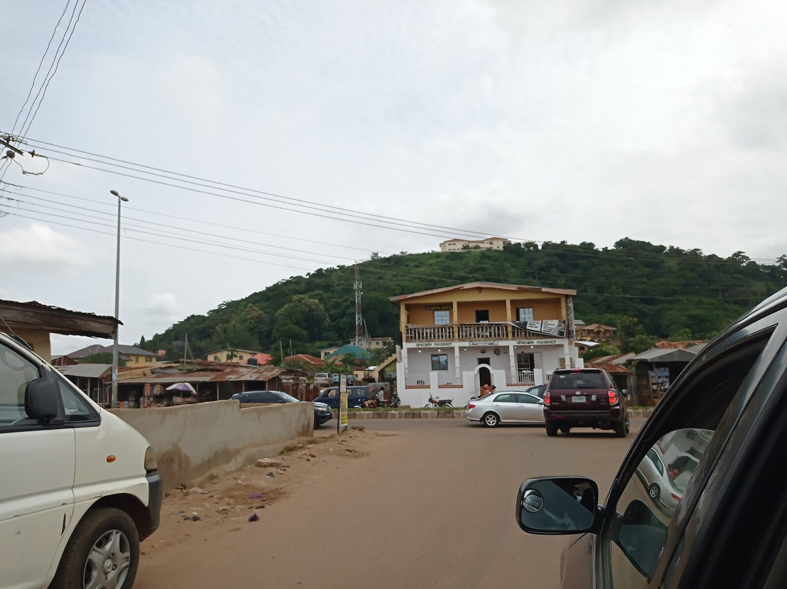 Front view of Ekiti State Government House building in Ado-Ekiti with palm trees and sky