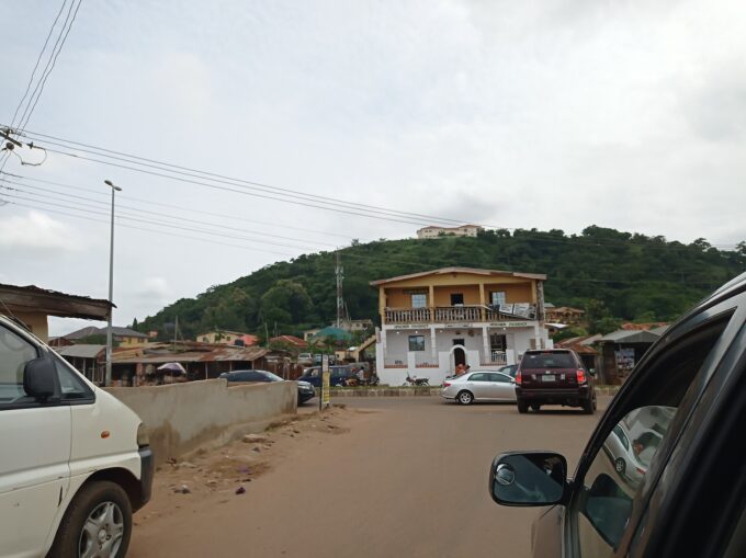 Front view of Ekiti State Government House building in Ado-Ekiti with palm trees and sky