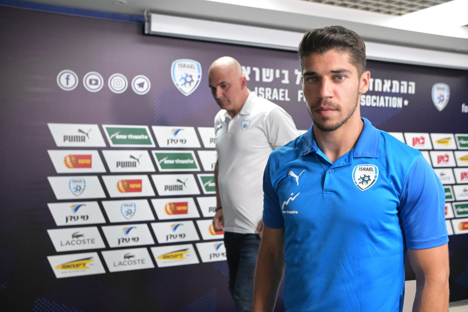 Manor Solomon at a press conference with microphones and Israel Football Association signage behind him